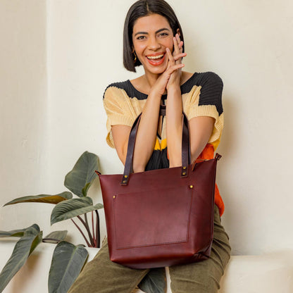 Cognac*Zipper | Model wearing larger leather tote bag with sturdy bridle handles and front pocket