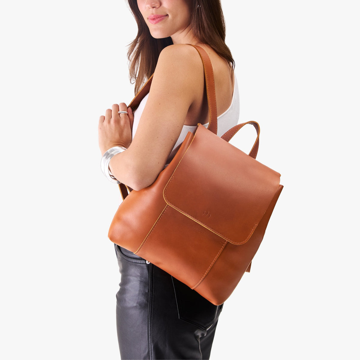 Honey | Model wearing a leather backpack on a white background
