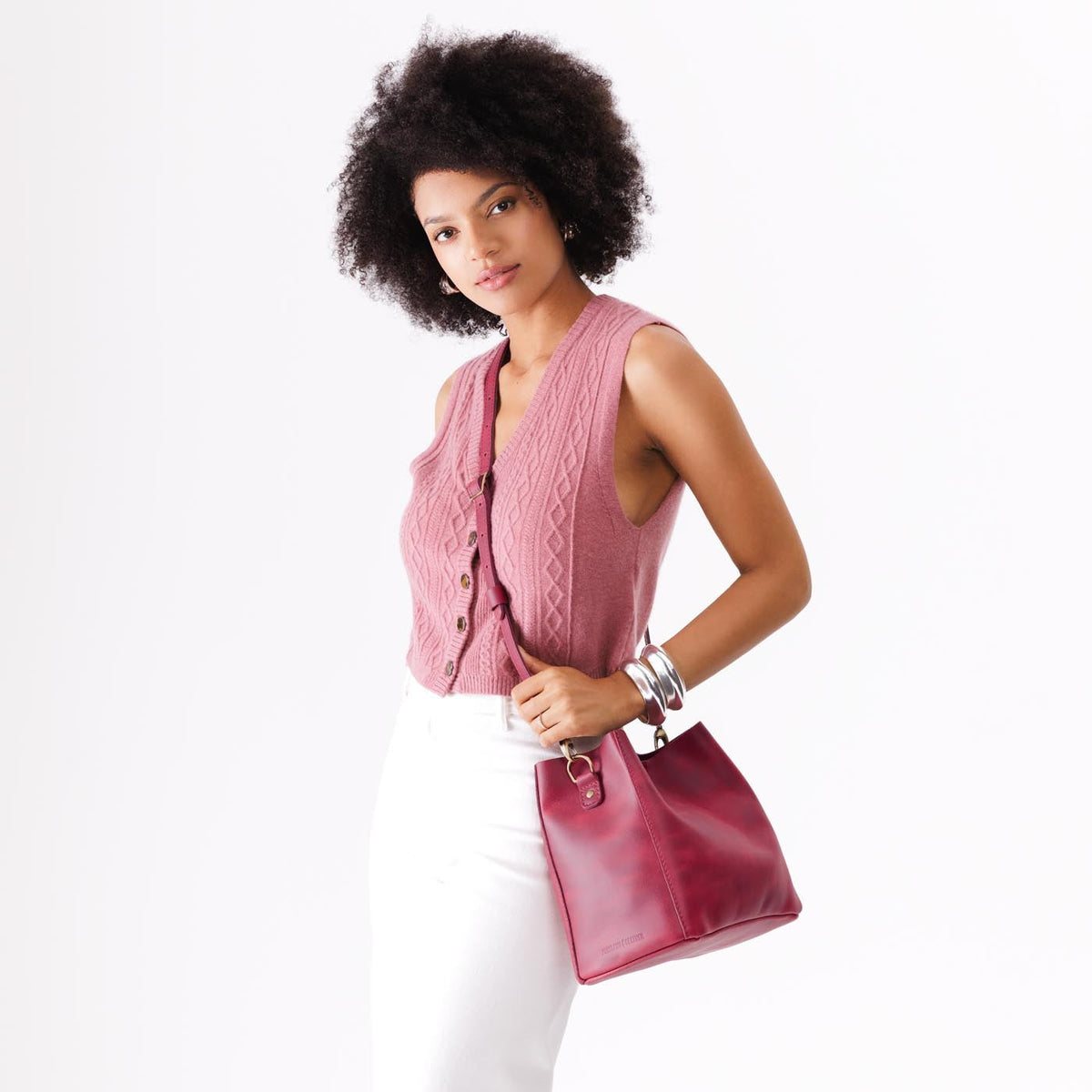Anemone | Model wearing symmetrical bucket bag with latch closure and removable crossbody strap