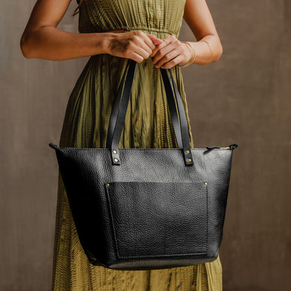 Pebbled--black*Zipper | Model holding large zipper leather tote bag with sturdy bridle handles and front pocket