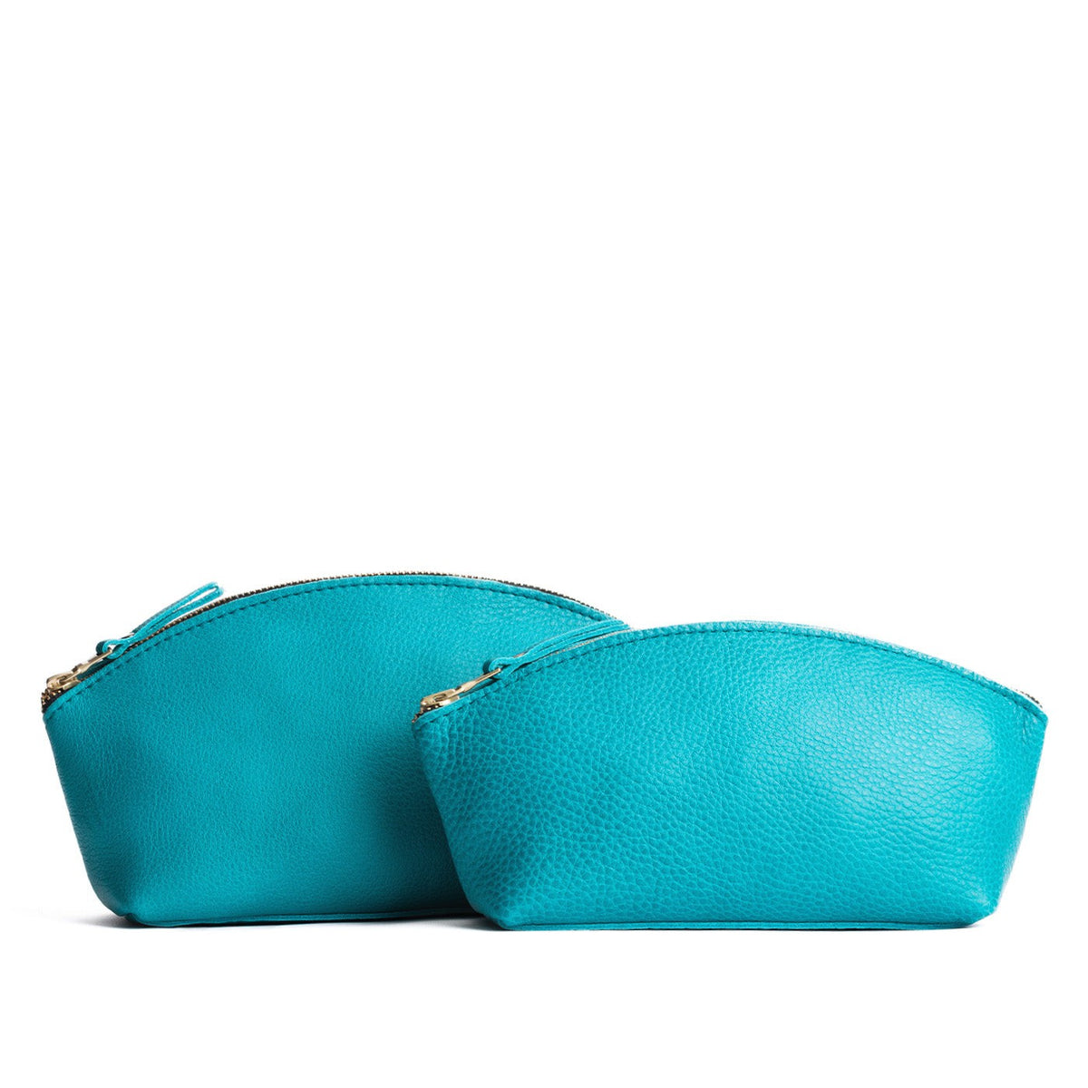 Baja | Size comparison shot of two spacious leather makeup bags with curved seams and top zipper