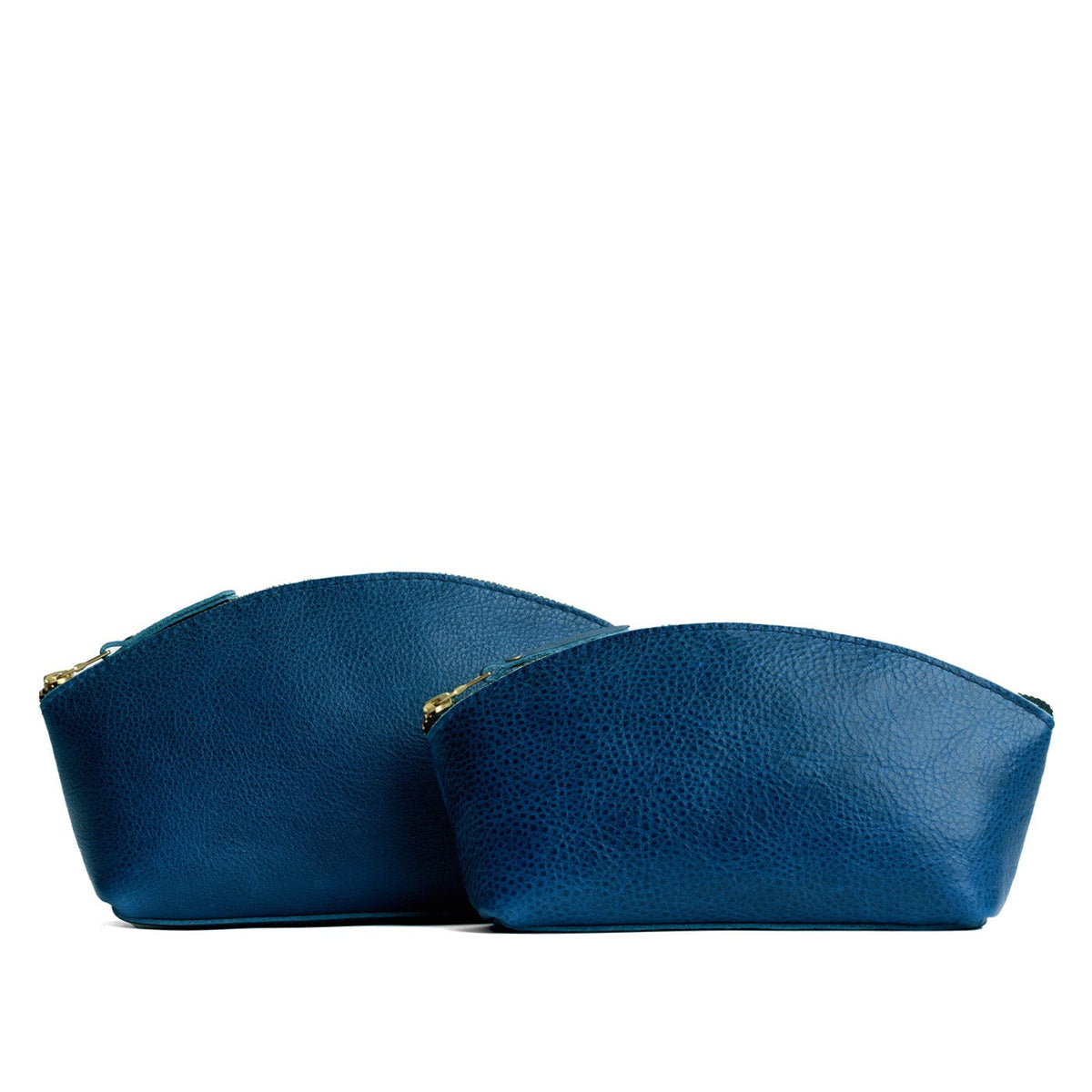 Caspian | Size comparison shot of two spacious leather makeup bags with curved seams and top zipper