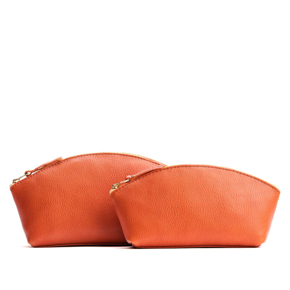Koi | Size comparison shot of two spacious leather makeup bags with curved seams and top zipper