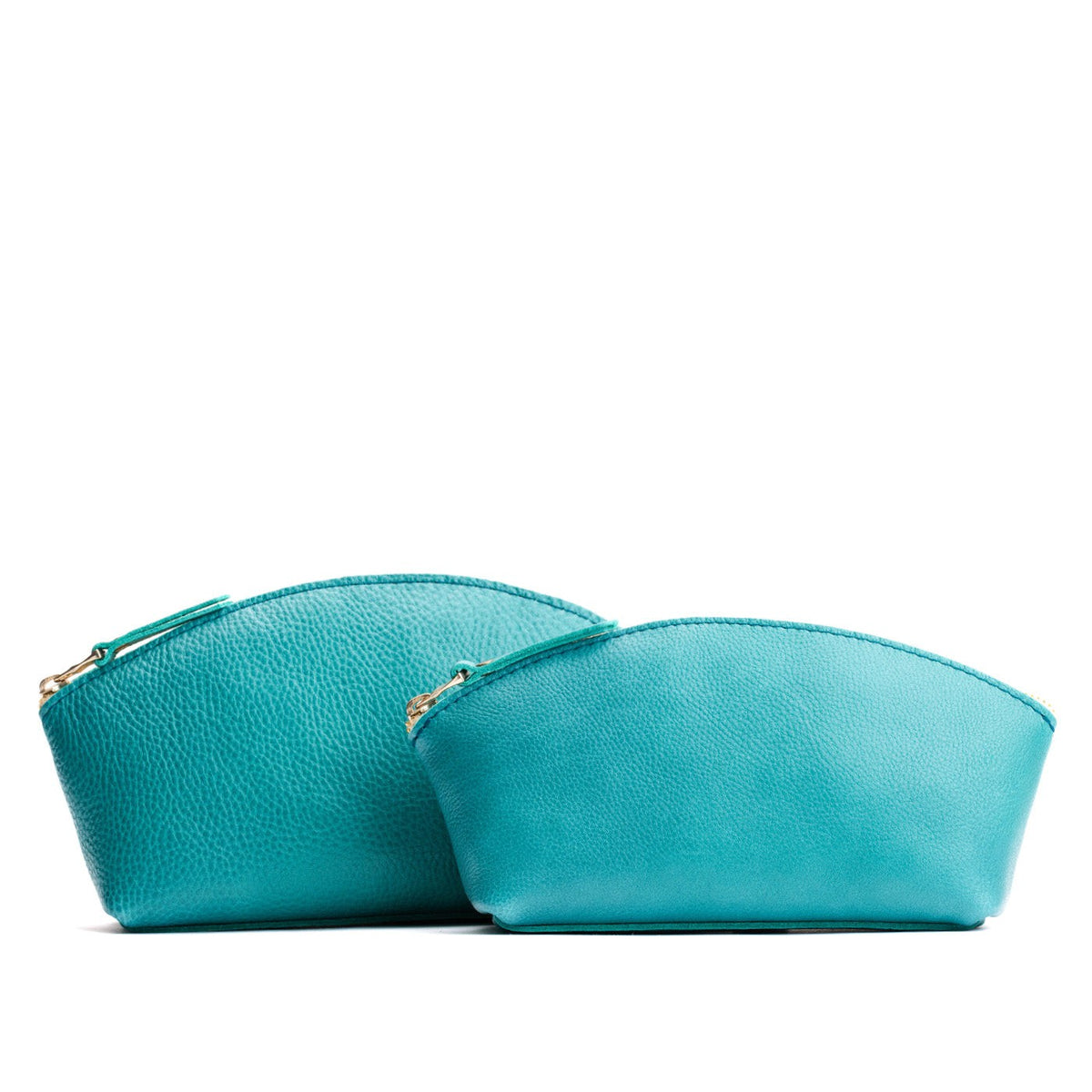 Seafoam | Size comparison shot of two spacious leather makeup bags with curved seams and top zipper
