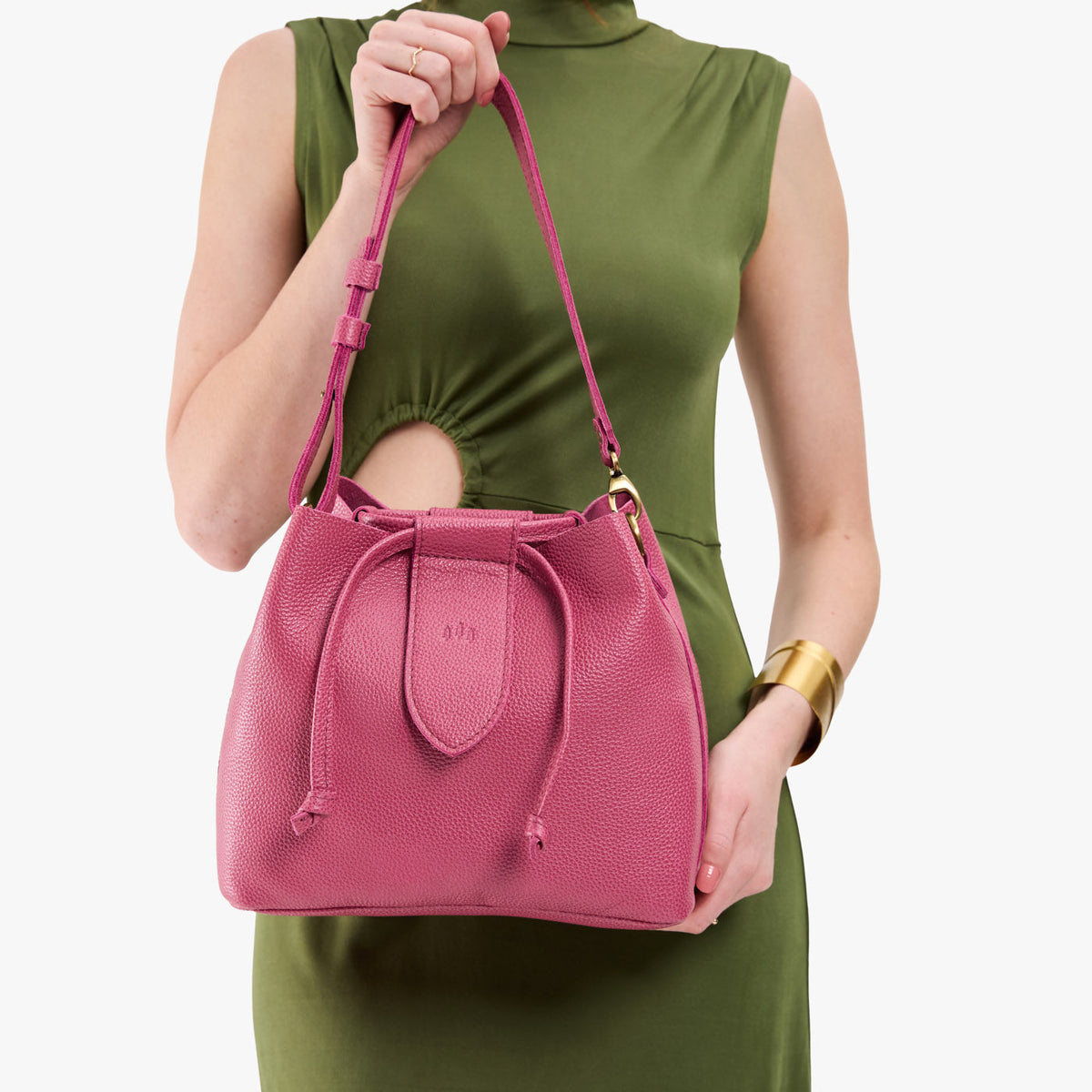 Wild Rose*Large | Model holding symmetrical leather bag with leather drawstring closure and adjustable shoulder strap
