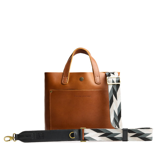 Moonstone | Patterned fabric and leather strap attached to leather purse on a white background
