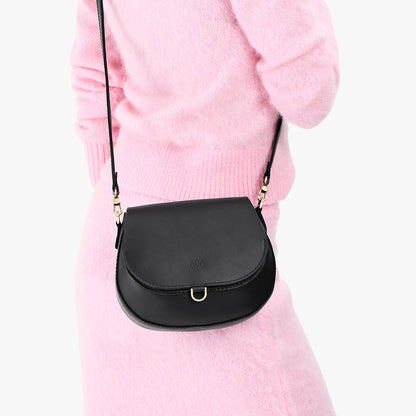 Black*Small | Model wearing a petite leather Crossbody with a flap and magnetic closure