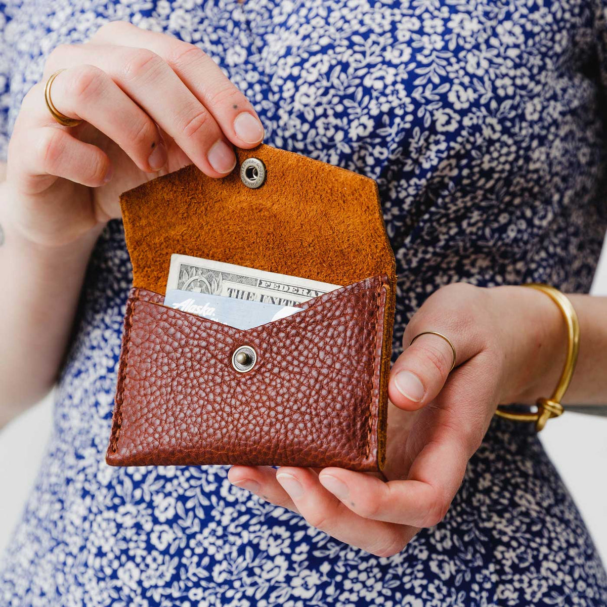 Nutmeg | Model holding small leather envelope wallet with snap closure open