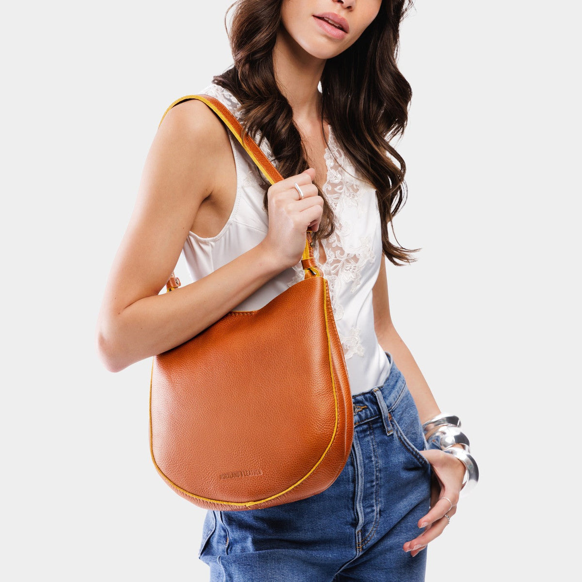 Sienna*Medium | Woman wearing rounded shoulder bag with adjustable strap on a white background