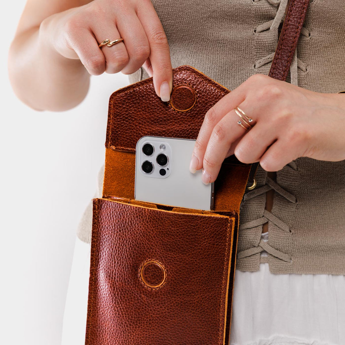 Nutmeg | Model wearing slim, phone-shaped crossbody purse with magnetic closure