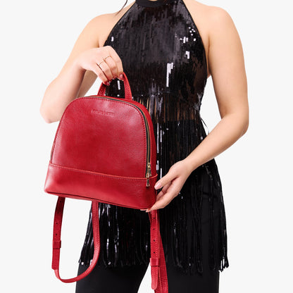 Reba Red | Model holding leather backpack with debossed Portland Leather logo on front