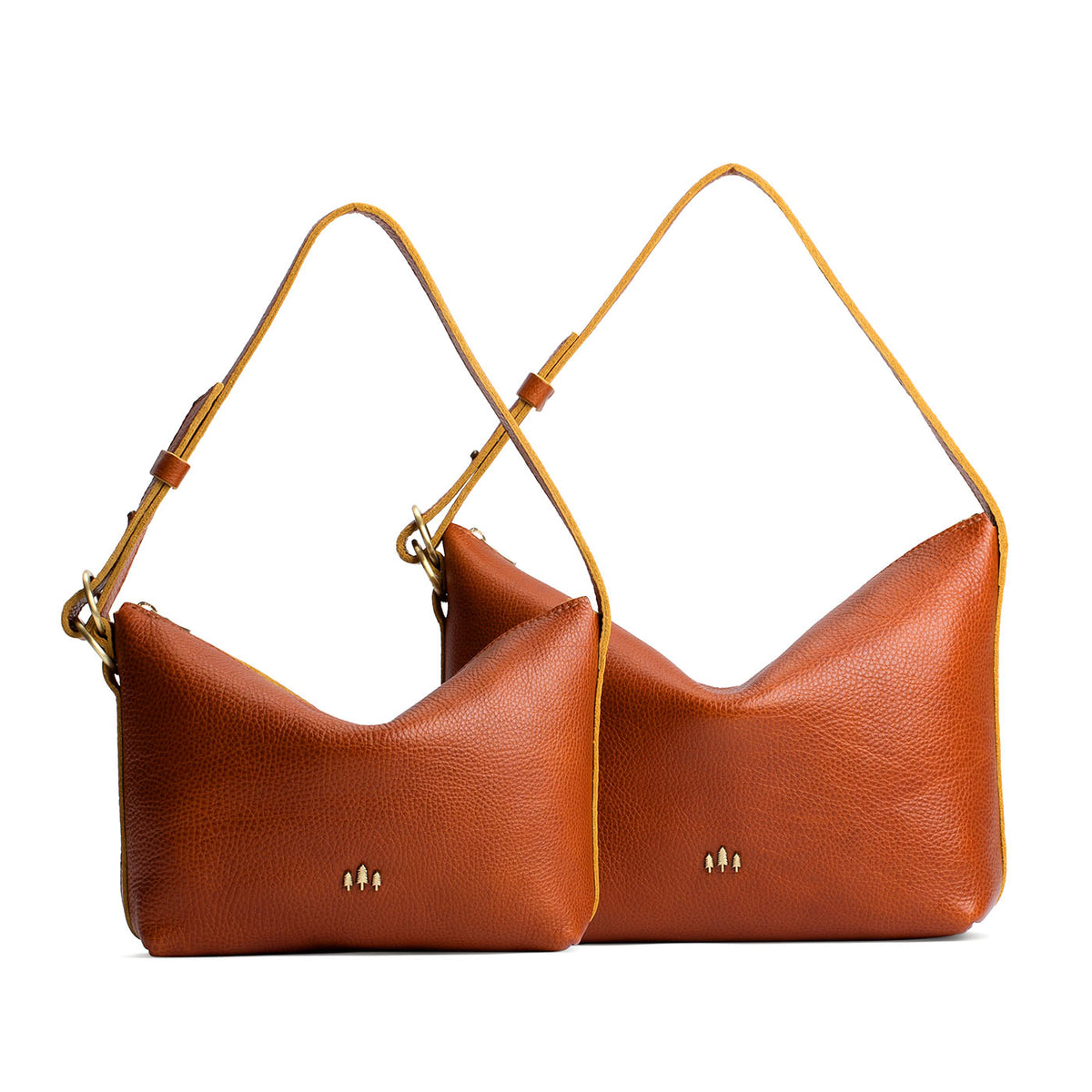Sienna | Size comparison shot of small and large slouchy leather shoulder bags with zipper opening and three metal tree emblems
