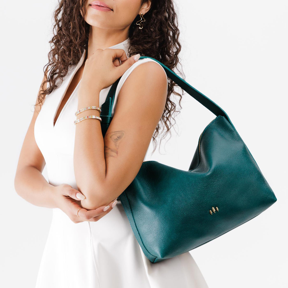 Sea Glass*Large | Model wearing medium sized slouchy leather shoulder bag with zipper opening and three metal tree emblems